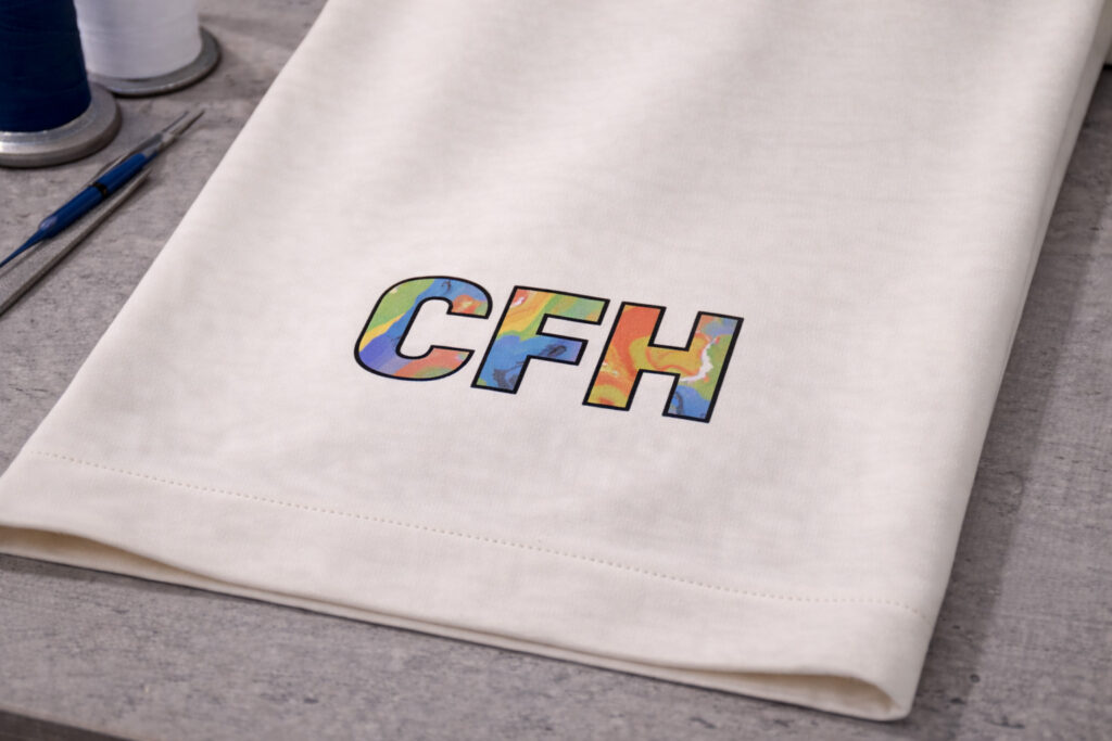 Digitaldruck-Veredelung mit mehrfarbigem CFH Logo auf Corporate Fashion und Teambekleidung